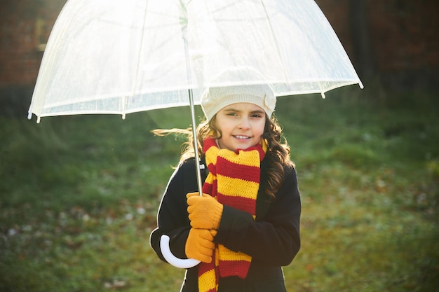 Niña con un abrigo azul con un blanco parque en otoño. foto de alta calidad | Foto Premium