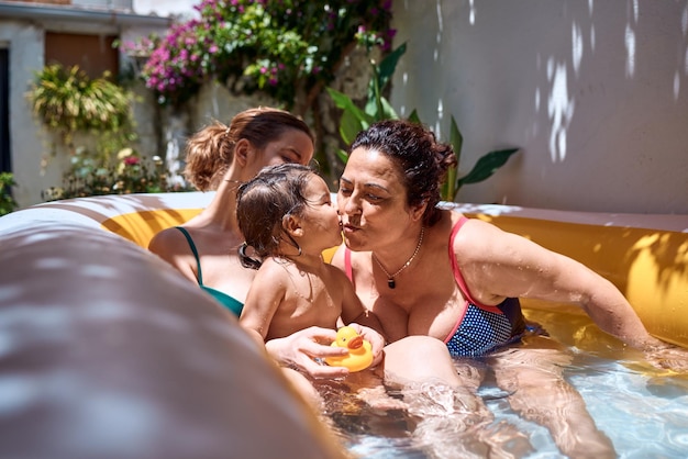 Foto una niña, una abuela y una niña pequeña están jugando en un concepto de vacaciones de piscina inflable