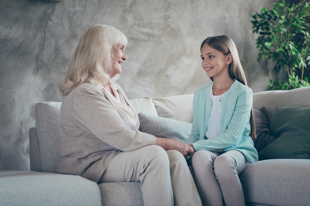 Niña y abuela sentada en el sofá