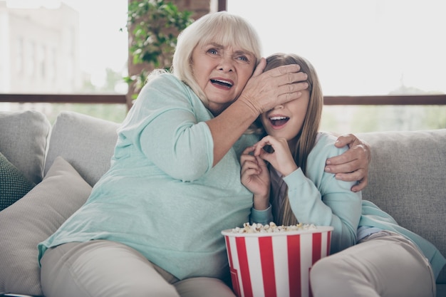 Niña y abuela sentada en el sofá