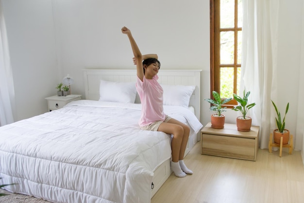 La niña acaba de despertarse y sentarse en la cama.