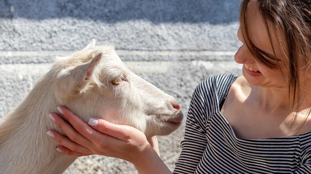 La niña acaricia al cabrito. Niña con una cabra