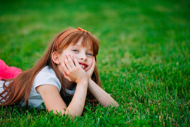 Niña acostada en la hierba