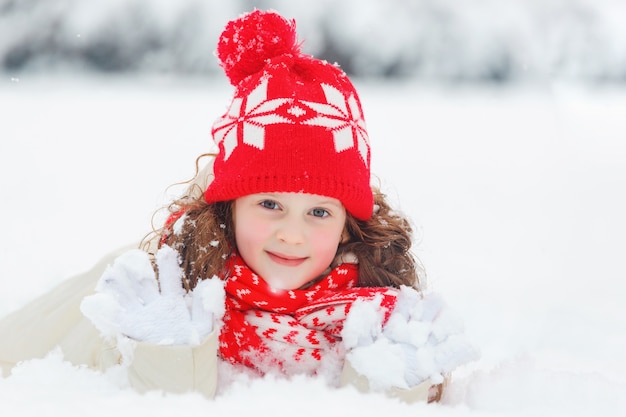 Niña acostada en la nieve.