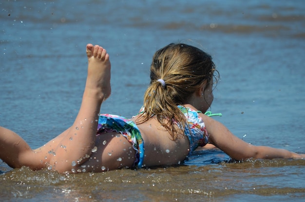 Foto niña acostada en la playa