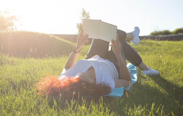 niña, acostado, en, pasto o césped, libro de lectura