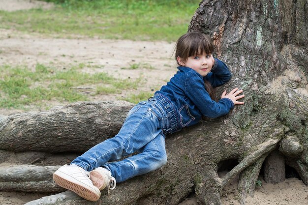 niña, acostado, en, el, raíces, de, un, árbol