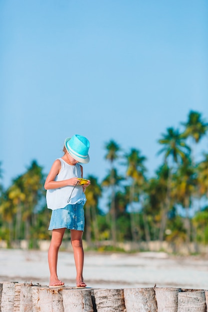 Niña activa en la playa blanca que se divierte.