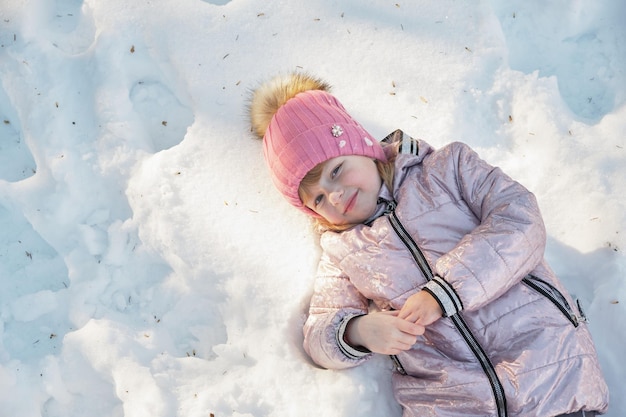 La niña se acuesta en la vista superior del espacio de copia de nieve