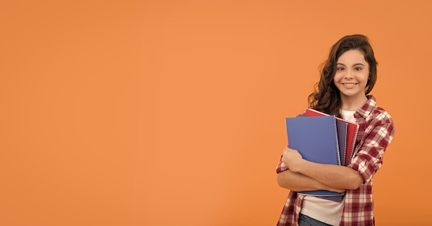 Niña adolescente de la escuela sonriente lista para estudiar con la escuela de cuadernos