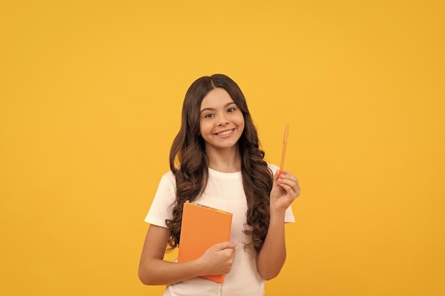 Niña adolescente de la escuela sonriente lista para estudiar con planificador y educación con pluma