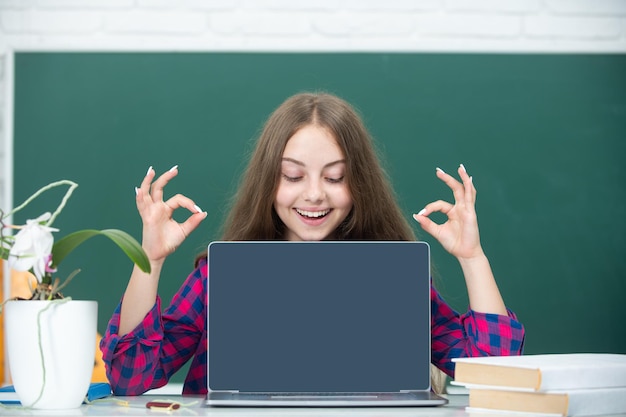 Niña adolescente estudiante con portátil en la escuela Estudiante adolescente trabajando en portátil en el aula Niña pequeña usando portátil estudiando en línea en la computadora Concepto de educación en casa Lección escolar