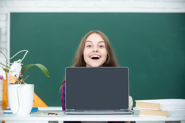 Niña adolescente estudiante con portátil en la escuela Estudiante adolescente trabajando en portátil en el aula Niña pequeña usando portátil estudiando en línea en la computadora Concepto de educación en casa Lección escolar