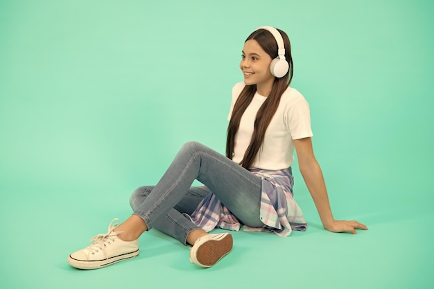 Niña adolescente feliz escuchar música en auriculares inalámbricos desarrollo infantil