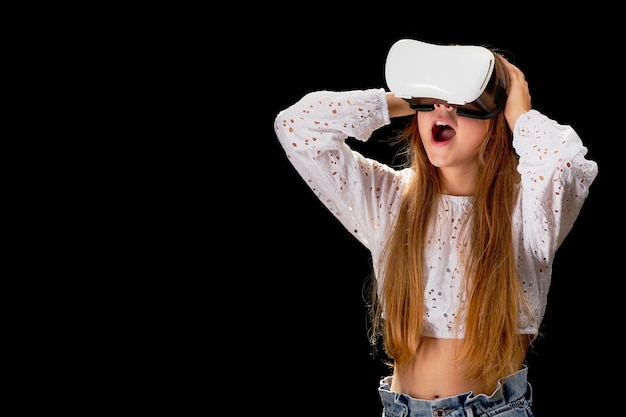 Niña adolescente con gafas VR e interactuando con el concepto de tecnología de entretenimiento de realidad virtual