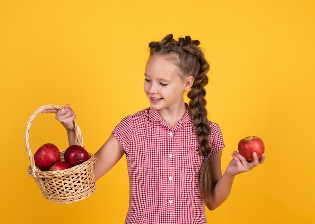 Niña adolescente lleva manzanas en la cesta cosecha de otoño temporada de primavera frutas llenas de vitaminas alimentos orgánicos solo natural y saludable niño de infancia feliz come manzana niño con fruta