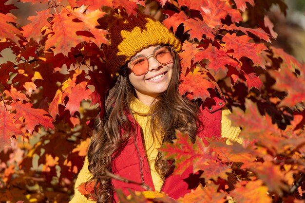 Niña adolescente en otoño hojas de otoño chica alegre de fondo en gafas de sol en hojas de otoño sobre fondo natural