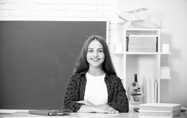 Niña adolescente sonriente regreso a la escuela conocimiento día educación concepto niño en el aula