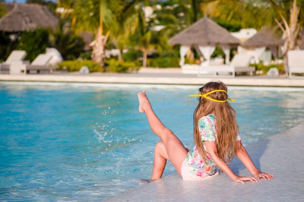 Niña adorable feliz en la piscina al aire libre