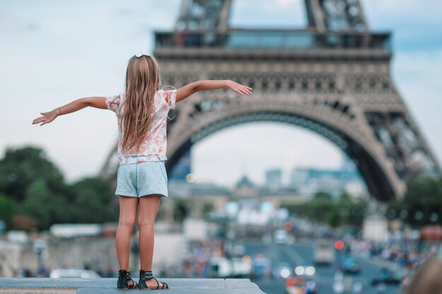 Niña adorable en París en la torre Eiffel durante las vacaciones de verano