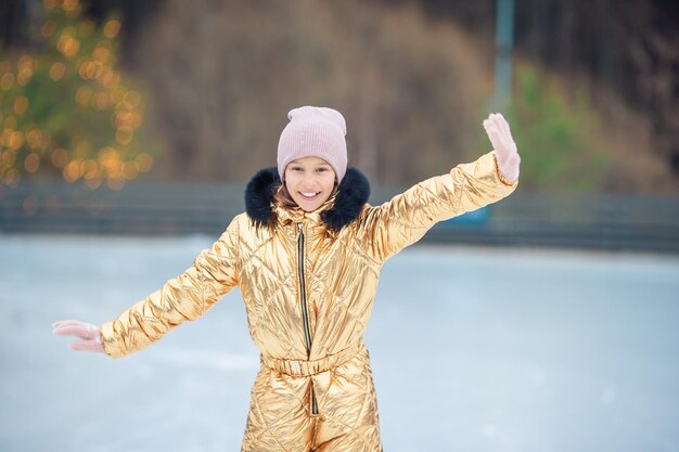 Una niña adorable patinando en la pista de hielo