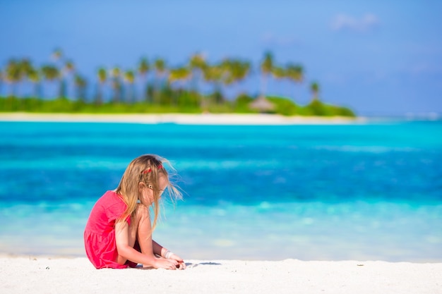 Niña adorable en la playa durante las vacaciones de verano