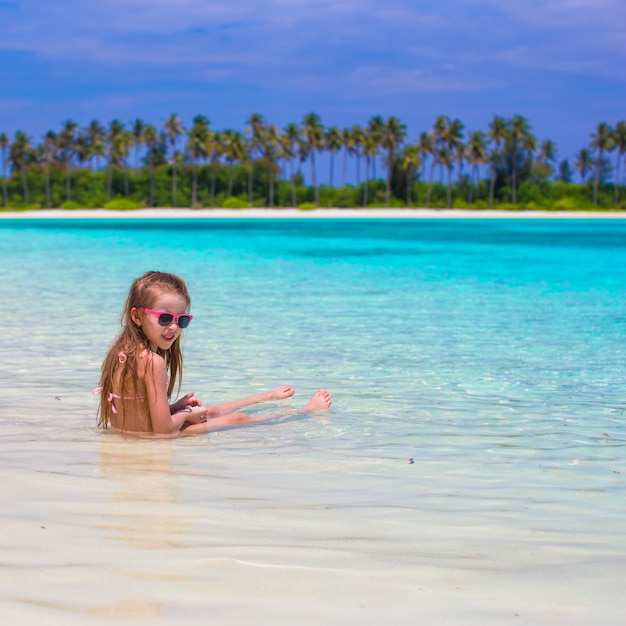 Niña adorable en la playa durante las vacaciones de verano