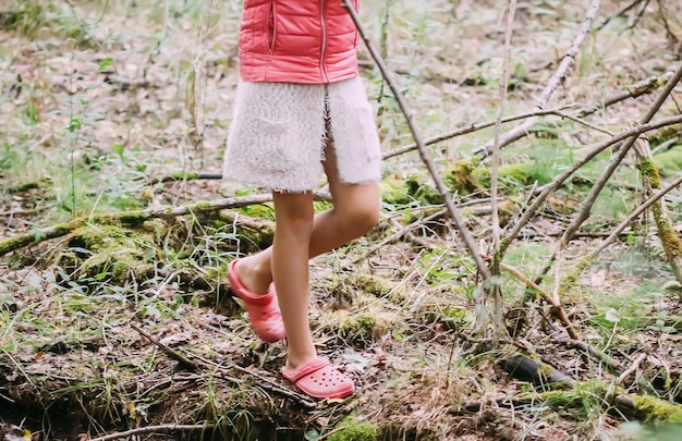 Niña adorable que camina en el bosque el día de verano