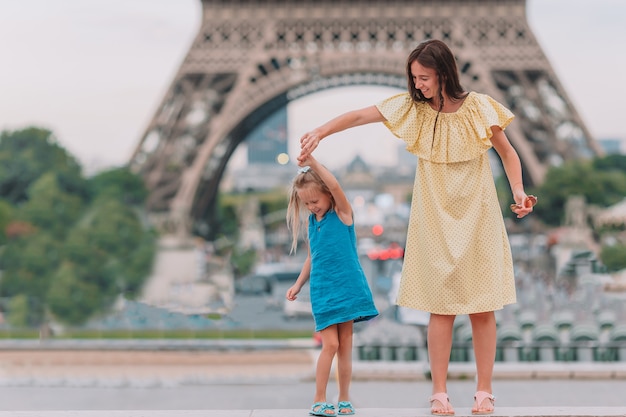 Niña adorable y su joven madre en París cerca de la Torre Eiffel durante las vacaciones de verano