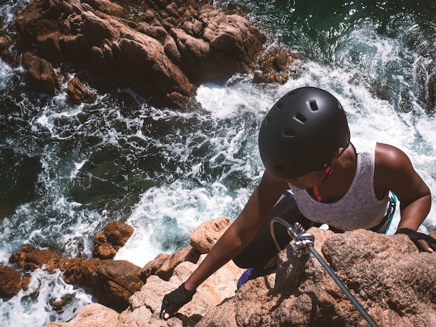 Foto niña africana haciendo una vía ferrata.