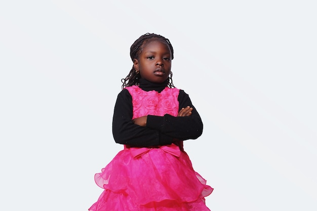 Foto niña africana con las manos cruzadas mirando despreocupado