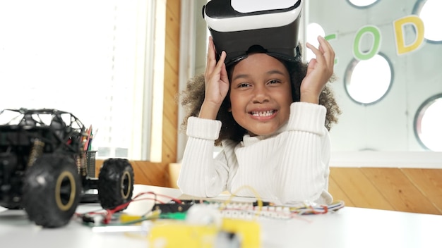 Niña africana quitándose el vidrio VR o el set de cabeza mientras mira la erudición de la cámara
