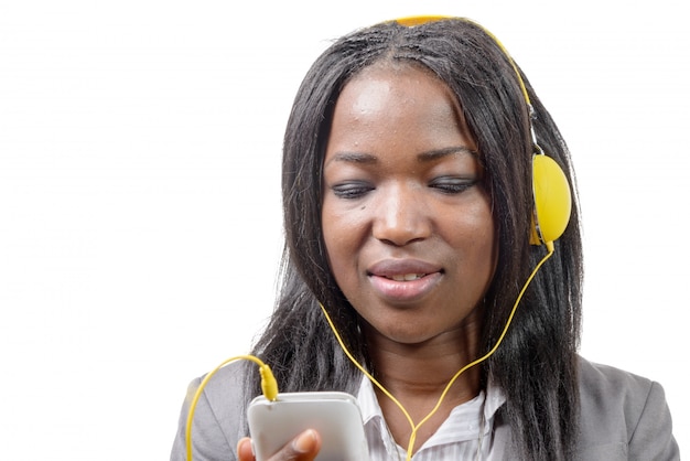 Niña africana con teléfono móvil y escuchando música