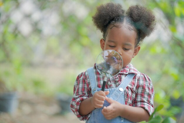 Niña afro que tiene actividades al aire libre en el jardín orgánico de la granja niño de familia diversa Concepto del día de la madre