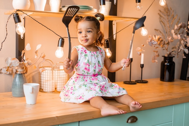 Niña afroamericana en la cocina de casa