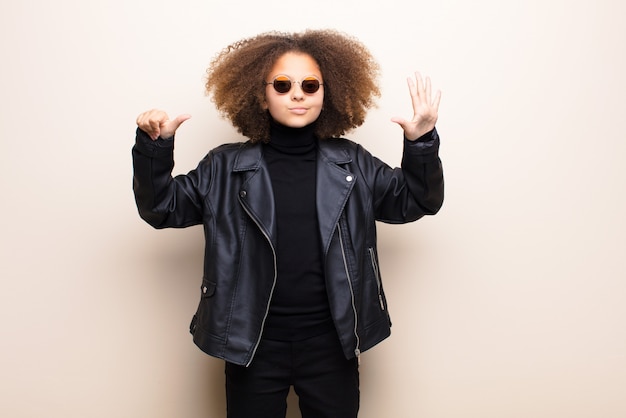 Niña afroamericana contra la pared plana. concepto genial