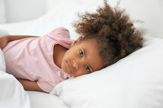 Niña afroamericana descansando en la cama