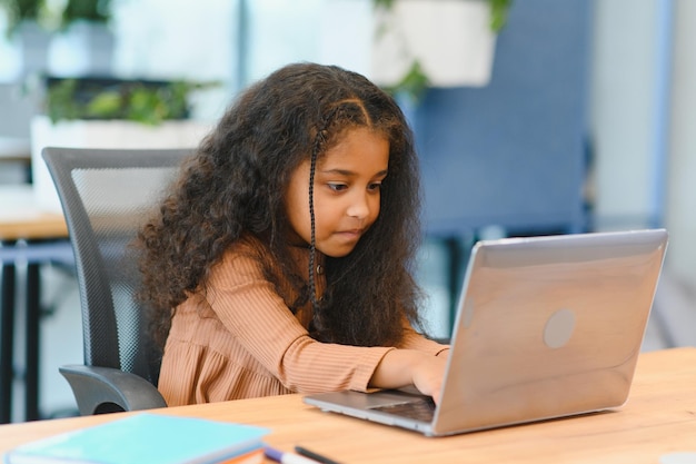 Niña afroamericana estudiando en una computadora portátil aprendizaje en línea