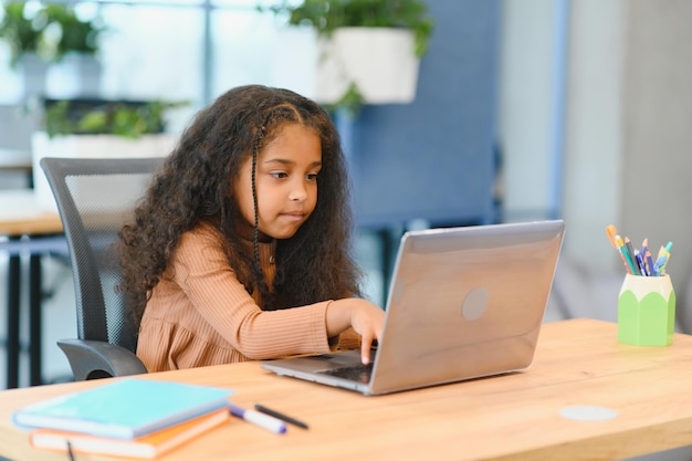 Niña afroamericana estudiando en una computadora portátil aprendizaje en línea