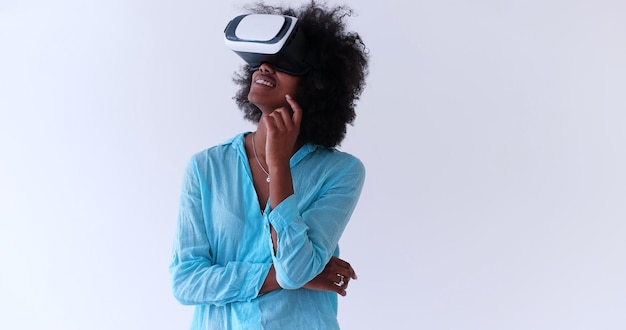 Niña afroamericana feliz obteniendo experiencia usando gafas de realidad virtual VR, aislada en fondo blanco