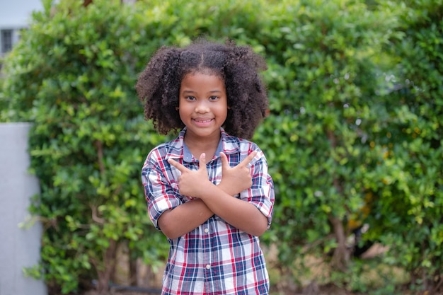 Niña afroamericana de pie y sonriendo confiada