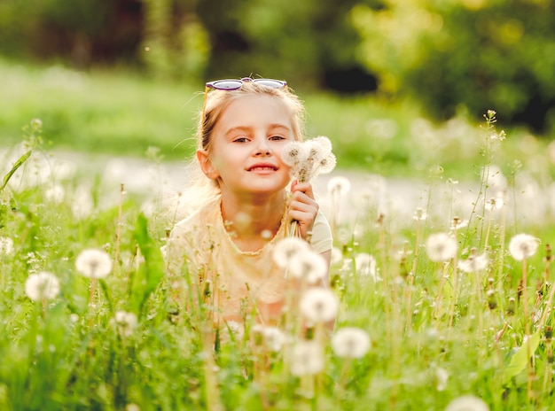 Niña afuera en el campo de diente de león