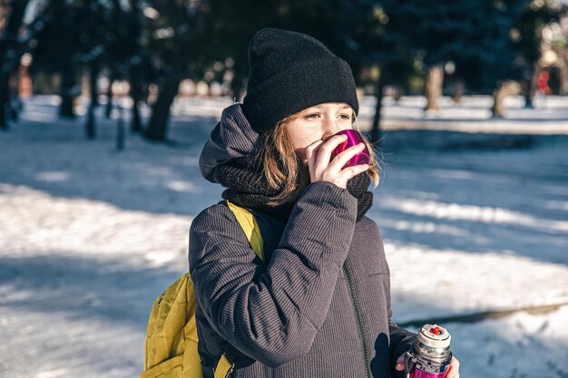 Una niña afuera con termo en un frío día de invierno.