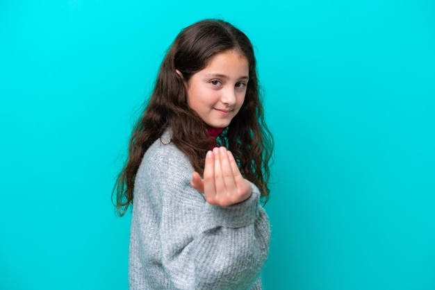 Niña aislada de fondo azul invitando a venir con la mano Feliz de que hayas venido