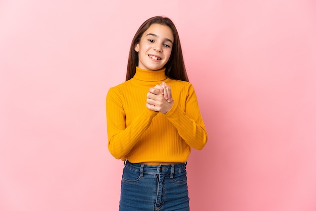 Niña aislada en la pared rosa riendo