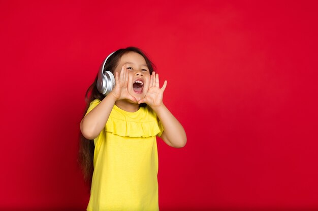 Foto niña aislada en rojo, feliz