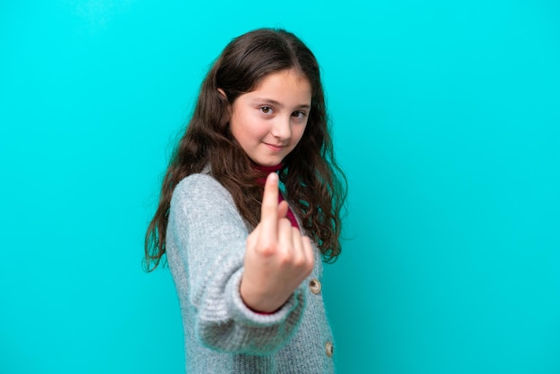 Niña aislada sobre fondo azul haciendo el gesto de venir