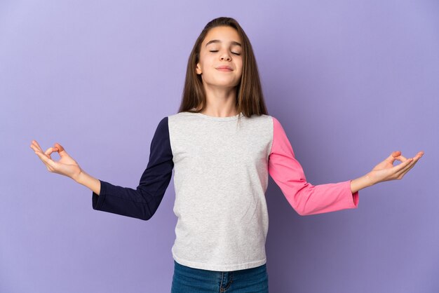 Niña aislada sobre fondo púrpura en pose zen