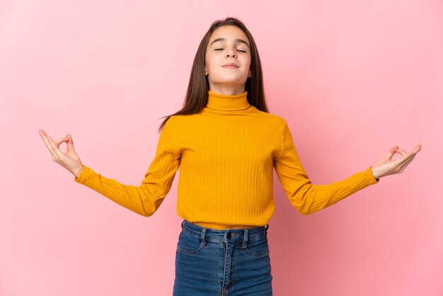 Niña aislada sobre fondo rosa en pose zen