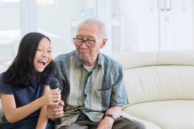 Niña alegre cantando con su abuelo